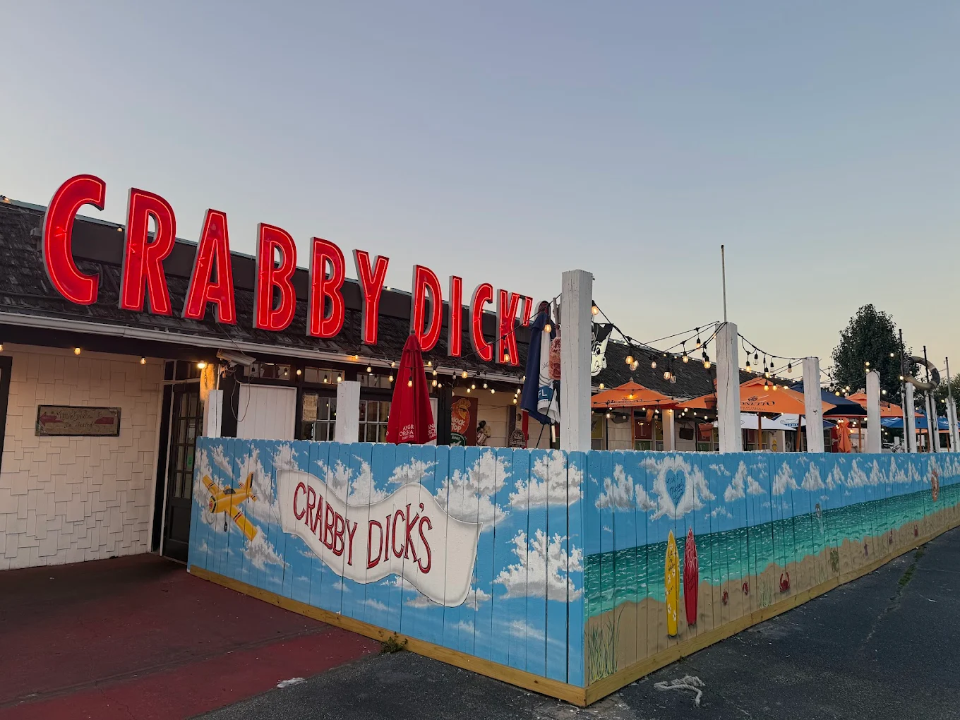 Crabby Dick's restaurant exterior with iconic red neon sign and beach mural
